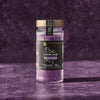 A jar of McCormick Flavor of the Year 2026 Black Currant Finishing Sugar sits on a textured purple surface.