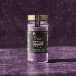 A jar of McCormick Flavor of the Year 2026 Black Currant Finishing Sugar sits on a textured purple surface.
