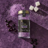 A jar of McCormick Flavor of the Year 2026 Black Currant Finishing Sugar is displayed with black currants, sugar cubes, and purple sugar crystals on a purple surface.