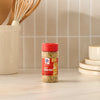 A bottle of Mccormick Spicy Sicilian Style Seasoning, 1.62 Oz is displayed on a kitchen countertop with utensils and plates in the background.