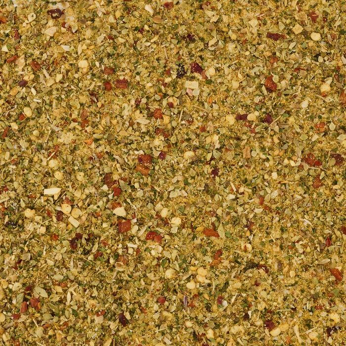A close-up, top-down view shows the texture of the Mccormick Spicy Sicilian Style Seasoning, 1.62 Oz, a blend of various dried herbs and spices.