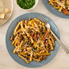 A delicious plate of gemelli pasta with ground meat and yellow peppers is garnished with fresh parsley and cheese, showcasing a meal made with Mccormick Savory Herb Parmesan Seasoning, 2.5 Oz.