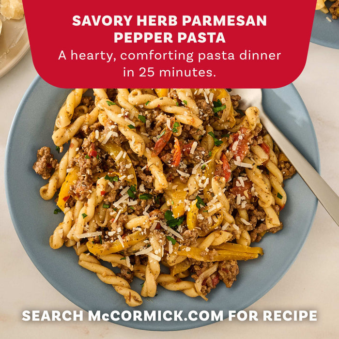 A close-up of a blue plate filled with Savory Herb Parmesan Pepper Pasta, a delicious meal idea made with Mccormick Savory Herb Parmesan Seasoning, 2.5 Oz.