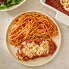 A plate of chicken parmesan and spaghetti, with the chicken topped with melted cheese and a sprinkle of Mccormick Savory Herb Parmesan Seasoning, 2.5 Oz.
