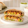 A homemade crunch wrap, seasoned to perfection with Mccormick Smoked Paprika And Garlic Seasoning, 3.12 Oz, is cut in half to reveal layers of beef, cheese, and lettuce.