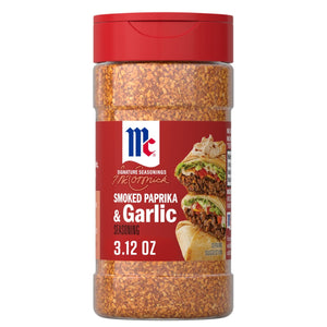 A clear bottle of Mccormick Smoked Paprika And Garlic Seasoning, 3.12 Oz, is shown against a white background, with a serving suggestion of seasoned wraps on the label.