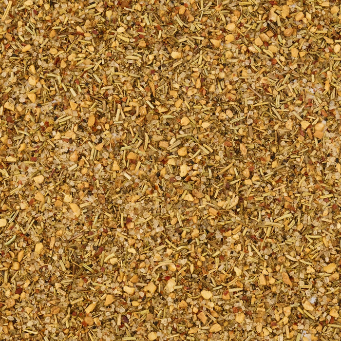 A detailed, top-down macro shot displays the texture of Mccormick Rosemary Lemon Seasoning, 2.75 Oz, with visible pieces of dried rosemary, salt, and spices.