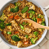 A light blue pan is filled with vegetable fried rice, made with broccoli, carrots, and egg, and seasoned with Mccormick Sesame Ginger Seasoning, 2.5 Oz.