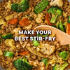A close-up of a colorful vegetable stir-fry with rice, broccoli, and carrots, which can be made with Mccormick Sesame Ginger Seasoning, 2.5 Oz.