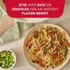 A plate of stir-fried udon noodles with meat and vegetables demonstrates how Mccormick Sesame Ginger Seasoning, 2.5 Oz can be stirred into noodles for an instant flavor boost.