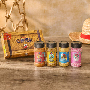 A collection of four limited-edition McCormick x Netflix One Piece seasonings, part of the Mccormick, 10.49 Oz product line, are displayed in front of their themed box on a wooden surface with a straw hat in the background.