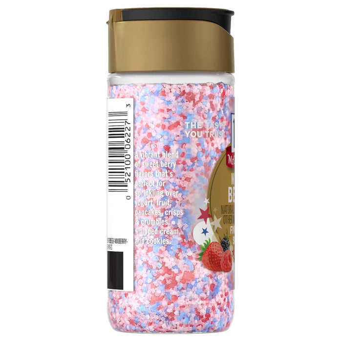 A side view of a clear shaker bottle of Mc Mixed Berry Fin Sgr 72/6/3.15 Oz shows the red, white, and blue sugar crystals inside, with the label detailing serving suggestions like yogurt, fruit, and pancakes.