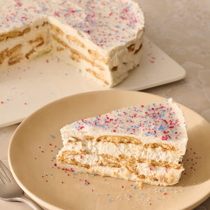 A slice of a layered icebox cake on a plate is topped with a festive garnish of Mc Mixed Berry Fin Sgr 72/6/3.15 Oz, with the rest of the cake in the background.