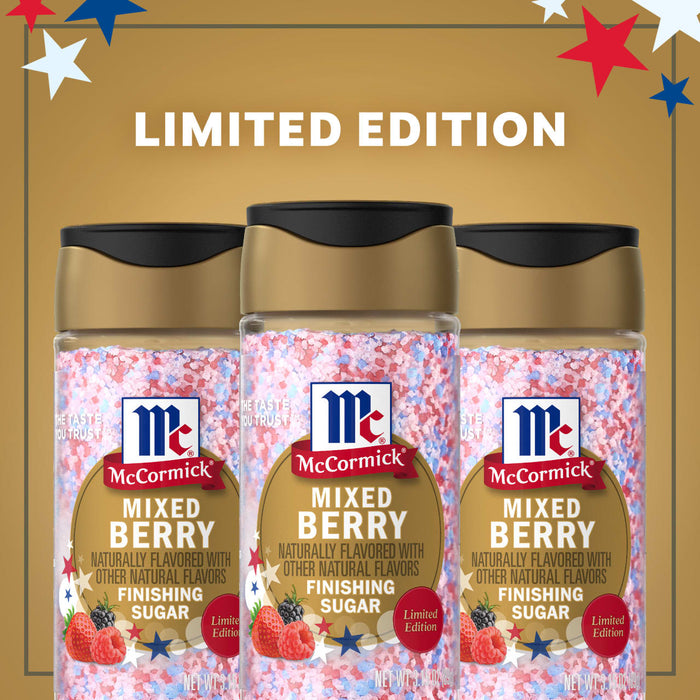 A promotional image for the limited edition Mc Mixed Berry Fin Sgr 72/6/3.15 Oz features three bottles of the red, white, and blue finishing sugar against a gold background with patriotic stars.