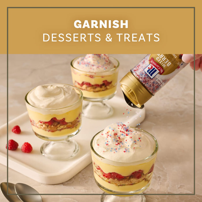 A hand garnishes layered berry trifles with a bottle of Mc Mixed Berry Fin Sgr 72/6/3.15 Oz, demonstrating how to use the product on desserts and treats.