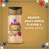 A bottle of Mccormick Apple Pie Finishing Sugar, 3.06 Oz, is featured in an advertisement highlighting its bright, juicy apple flavor and warm spice against a festive, star-decorated background.