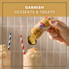 A hand sprinkles Mccormick Apple Pie Finishing Sugar, 3.06 Oz over a milkshake topped with whipped cream to demonstrate how to garnish desserts and treats.