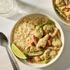 A bowl of creamy green curry with chicken and vegetables served alongside white rice and a lime wedge is prepared using Mc Thai Gn Curry Mix.