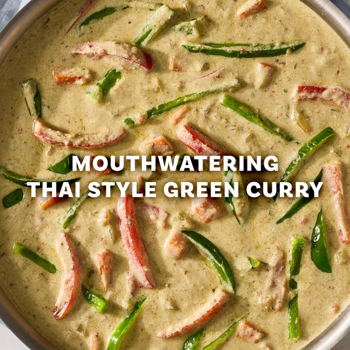 A close up view of a creamy and mouthwatering Thai style green curry prepared with Mc Thai Gn Curry Mix featuring sliced red and green bell peppers.