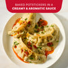A white plate holds baked potstickers smothered in a creamy and aromatic sauce made with Mc Thai Gn Curry Mix and topped with chili oil and fresh herbs.