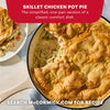 A golden brown skillet chicken pot pie made with Mc Chkn Pot Pie Mix is served in a white cast iron pan with a portion plated on the side.