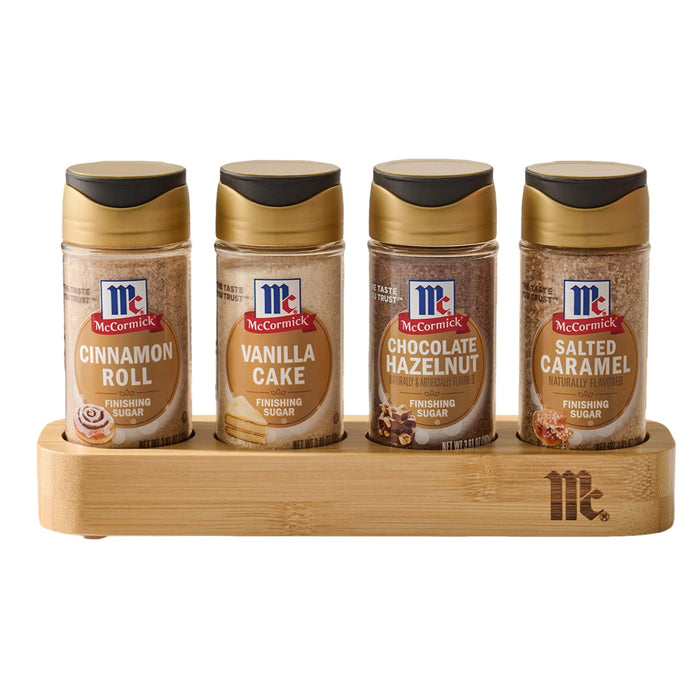 The Mccormick Finishing Sugar Caddy 4Ct is displayed against a white background, holding four jars of finishing sugar in Cinnamon Roll, Vanilla Cake, Chocolate Hazelnut, and Salted Caramel flavors.