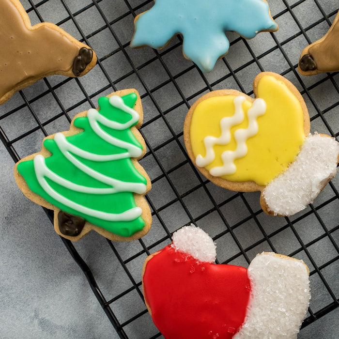 ['Decorated Christmas cookies on a wire rack.']