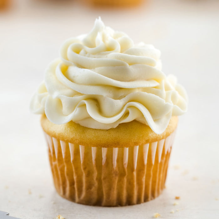 A delicious cupcake with creamy white frosting.