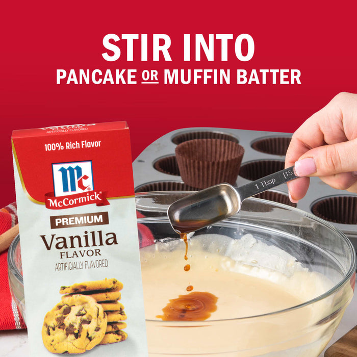 A box of McCormick Vanilla Flavor is shown as a tablespoon of vanilla extract is being poured into pancake or muffin batter.