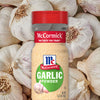 A bottle of McCormick Garlic Powder surrounded by garlic cloves.