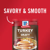 ['A package of McCormick Turkey Gravy with a picture of sliced turkey with gravy, cranberry sauce, and stuffing on a white plate.']