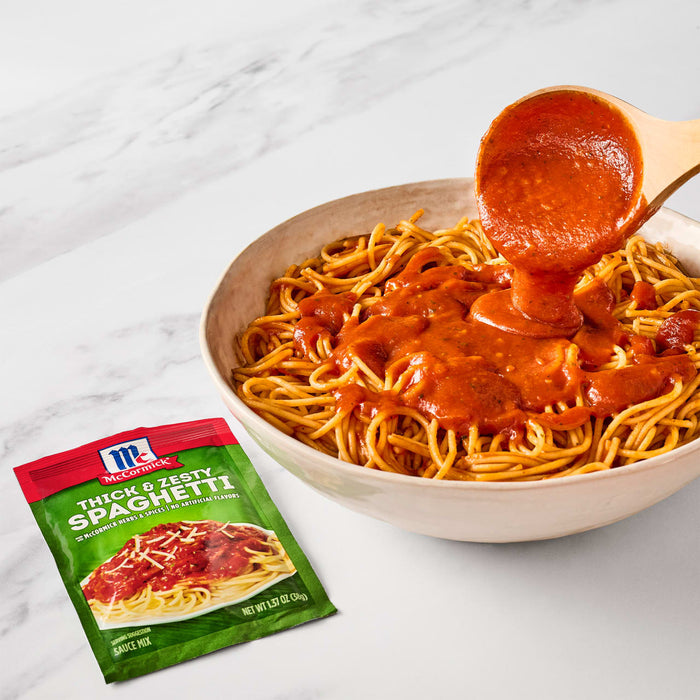['A bowl of spaghetti with McCormick Thick &amp; Zesty Spaghetti sauce being poured over it.']