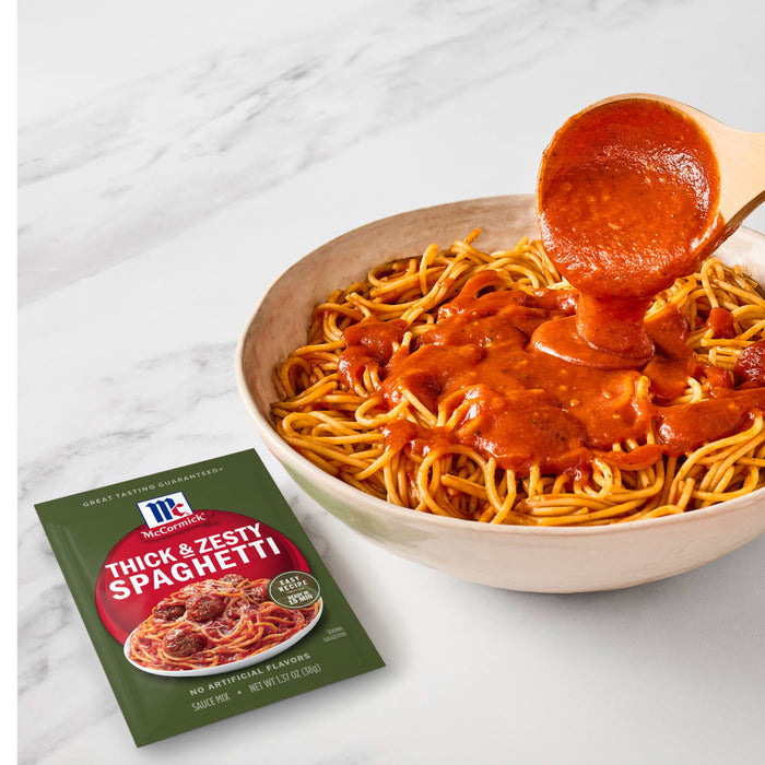 A bowl of spaghetti with McCormick Thick &amp; Zesty Spaghetti sauce being poured over it.