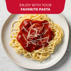 McCormick Thick &amp; Zesty Spaghetti sauce mix with a bowl of pasta and a pot of sauce.