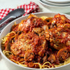 ['A bowl of spaghetti with chicken and mushrooms in a tomato sauce.']