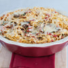 ['A close-up of a casserole dish filled with spaghetti, zucchini, and melted cheese.']
