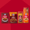 A vibrant red background showcases four different packaging options for McCormick Original Chili seasoning, including a single packet of Mccormick Chili Seasoning Mix 1.25 Oz, a 6-pack box, and two shaker bottles, each displaying a bowl of chili on its label.