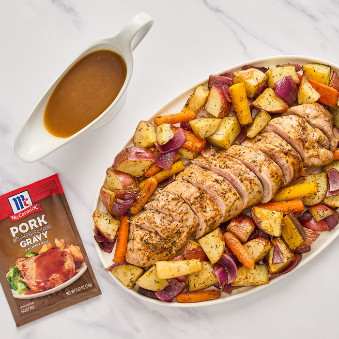 ['McCormick Pork Gravy mix with a serving suggestion of roasted pork, potatoes, carrots and onions.']