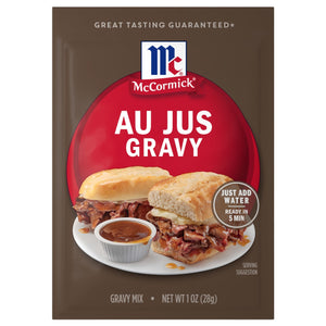 A brown packet of Mccormick Au Jus Gravy Mix 1 Oz featuring a serving suggestion of two roast beef sandwiches with a side of dipping sauce.