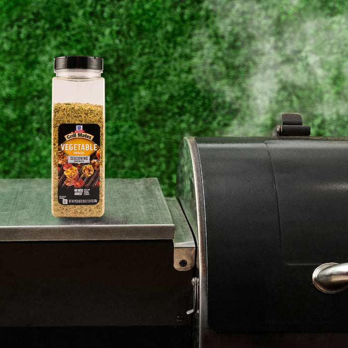 A bottle of Pit Boss Grilla Rub seasoning sits next to a smoker, suggesting its use in grilling.