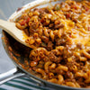 A close-up of a skillet filled with a cheesy beef and macaroni dish.