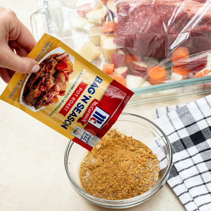 ["A hand pours McCormick Bag'N Season into a bowl."]