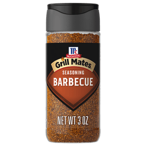 A clear plastic bottle of Mccormick Grill Mates Barbecue Seasoning, featuring a black label with the brand logo and product name, filled with reddish-brown spice.