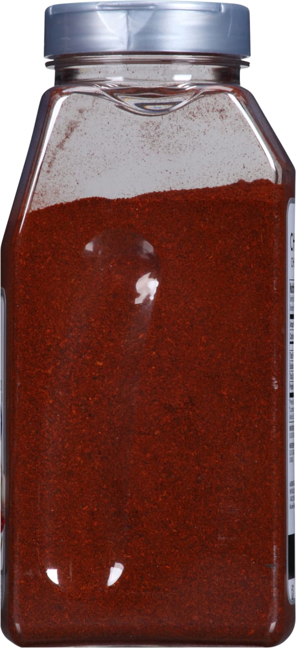 A clear plastic jar filled with red chili powder.