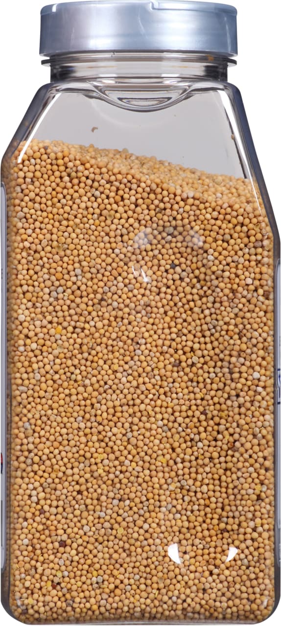 A clear plastic jar filled with yellow mustard seeds.