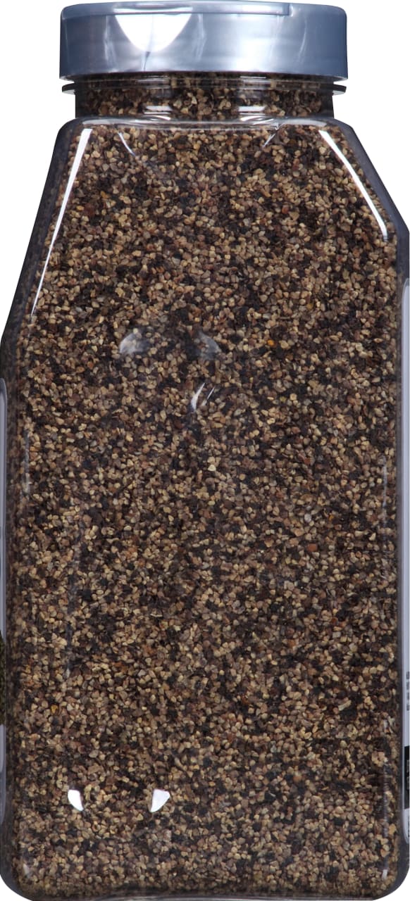 A close-up of a glass jar filled with black peppercorns.