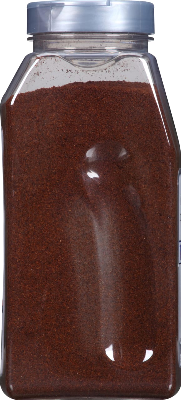 A clear plastic jar filled with ground red pepper.