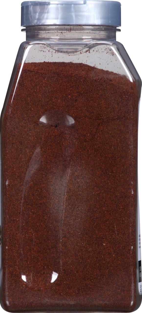 A clear plastic jar filled with a dark red spice.