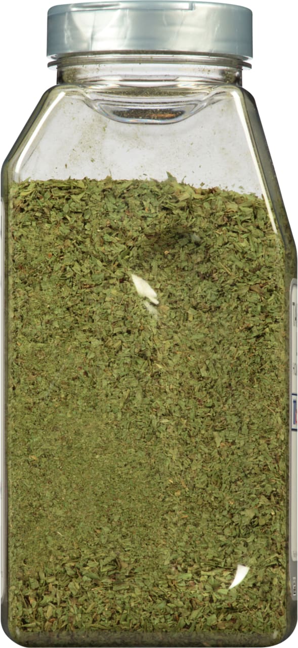 A glass jar filled with dried parsley.