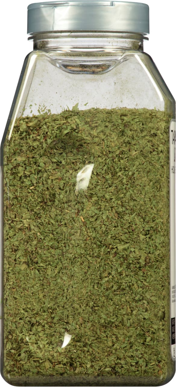 A glass jar filled with dried tarragon.
